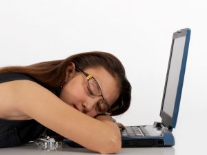 alt= "Woman bored at work asleep on her keyboard"