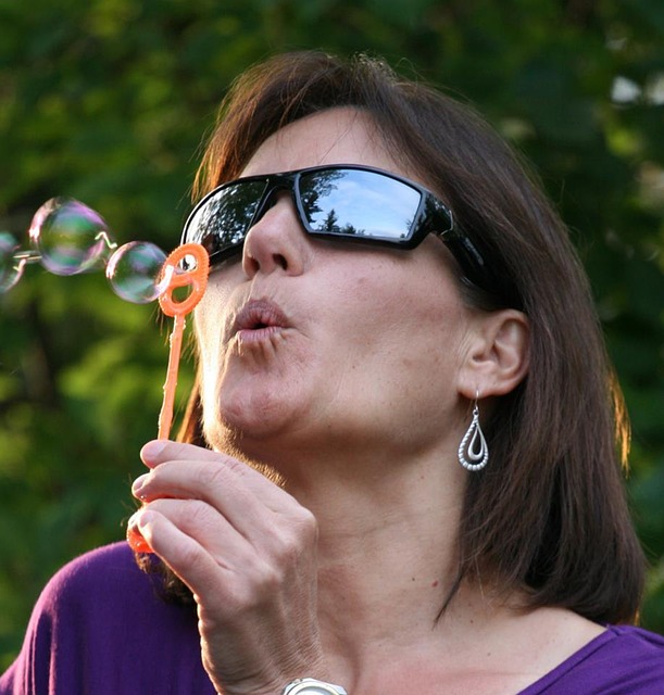 alt= "Woman blowing bubbles showing the concept of letting go to receive"