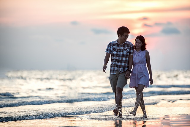 alt= "A couple in a relationship walking on the beach"